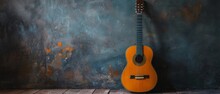 Acoustic Guitar Against Gray Wall
