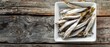 Anchovies on white plate on wooden board