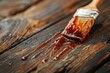 BBQ sauce drips from basting brush onto table with blurred background