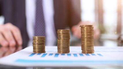 Wall Mural - Businessman stacking coins on table, business growth concept. Hand puts coin to stack.