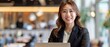 Happy Asian businesswoman working on laptop in office attractive female employee in formal suit smiling at work