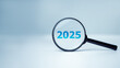 © Thawatchai Images - A magnifying glass and text 2025 new year idea concept. Planning goals and success concept, 2025 present in focus business