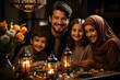 Happy Muslim family eat together at home at table with national dishes on the table, sweets and desserts. Holidays Ramadan, Eid al Adha, Eid Mubarak . Family dressed in national clothes