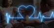 Image of neon heart rate and heart over happy biracial couple, woman on wheelchair