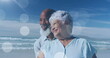 Image of happy senior african american couple embracing at beach over light spots