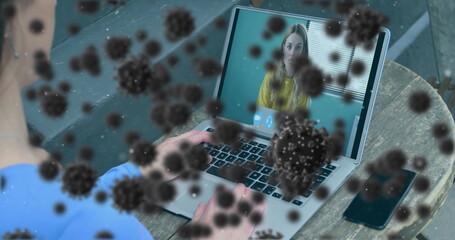 Wall Mural - Image of covid 19 cells over businesswoman on laptop image call