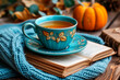 A cozy scene with a blue vintage teacup on a saucer, an open book, and a knitted throw, evoking a sense of warmth and comfort.