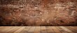 There is a hardwood flooring in front of a brown brick wall, creating a beautiful contrast between the wood and brickwork building material