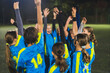 © PoppyPix - young football player girls standing in a circle holding hands up and preparing for the game, teamworking. High quality photo
