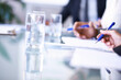 © Mikolette Moller/peopleimages.com - Business, hands and documents for writing in meeting with brainstorming, planning and water in conference room. Corporate, employees and paperwork by table in boardroom for collaboration and strategy
