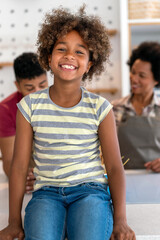 Wall Mural - Happy smiling african american parents enjoy weekend play with child in kitchen. Family love concept