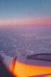 Airplane flying over a snowy landscape in Rovaniemi, Finland on a beautiful cloudy sunset sky with aircraft wing