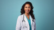 Lächelnde Ärztin vor hell blauem Hintergrund