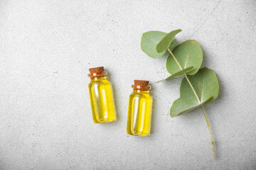 Wall Mural - Eucalyptus essential oil in a glass bottle with green eucalyptus leaves on a textured wooden background. Aromatherapy concept. Spa. Natural organic ingredients for cosmetics and body care.Copy space