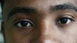 © Marco - Macro closeup of a young black man eyes staring at camera with intense gaze in solemn serious expression, eye to eye - facial features
