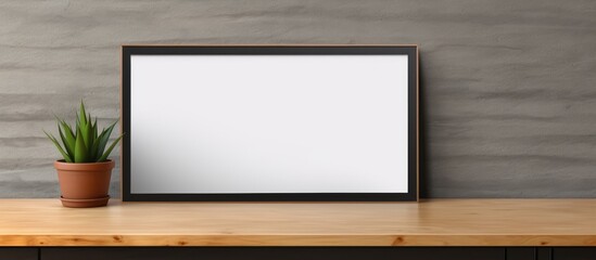 Poster - A rectangular picture frame sits on a wooden table next to a flowerpot with a houseplant. The still life photography captures a multimedia display device in a cozy event setting