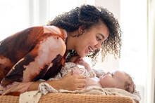 A joyful moment between mother and baby bathed in soft light.