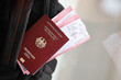 Red German passport of European Union with airline tickets on touristic backpack close up. Tourism and travel concept