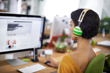 Poster - Business, designer and woman with headphones at computer screen in office for creative internship and web design. Employee, rear view and monitor for multimedia production and video animation at desk
