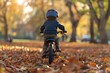 Child riding bike in sunny autumn park