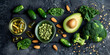 Food background set of food on an old black background the concept of healthy eating ,Green vegetables fruits and nuts avocado broccoli pistachios parsley celery cucumber and kiwi top view rustic sty
