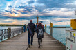 Lovely view of a couple walking on the pier, approaching the famous Imperia statue at the harbour entrance of Constance (Konstanz) by Lake Constance (Bodensee) in Germany on a nice evening.