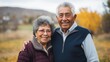 © PaulShlykov - Closeup portrait, retired couple in casual shirt and dress holding each other smiling,enjoying life together, outside green trees background.