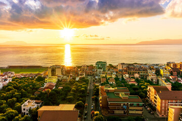 Wall Mural - panoramic summer travel view from a hill to  beautiful sea coast historical town with port, amazing ocean bay and gulf and beautiful mountains with scenic sunset on background.