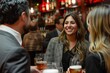 Friendly Networking Event at a Cosy Bar. Smiling young woman engaging in a conversation at a vibrant networking event in a cozy bar with beer glasses.