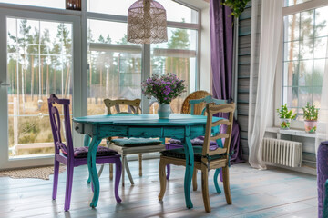 Wall Mural - Rustic, vintage furniture, table and chairs of various bright colors in the dining room with large windows.