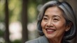 © AcaciaDaydreams - Portrait of a middle-aged asian woman with gray hair. Beautiful smile. The concept of natural beauty and beautiful aging. Light background.