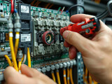 Fototapeta Panele - Electrical engineer checking the operation of an electrical circuit board