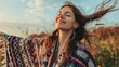 Young woman wearing colorful poncho relaxing in beautiful nature with opened arms. Spirituality, harmony and connection with nature concept.