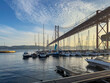 Lisbon docks with boats and views of the 25 de Abril bridge. With sunset.