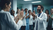 © MP Studio - A group of healthcare professionals in lab coats clapping and smiling, seemingly celebrating or acknowledging a success or achievement.