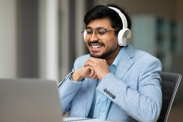 Aufkleber - hindu businessman using laptop and headset video calling in office