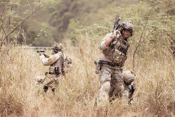 Wall Mural - Soldiers in camouflage military uniforms carrying weapons, Reconnaissance missions in the tropical forest area with mission of helping those injured from being shot