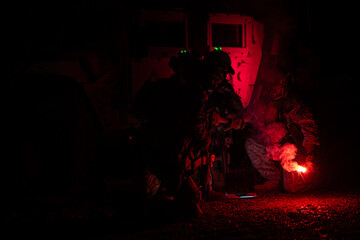 Wall Mural - Group of soldiers in camouflage uniforms hold weapons with patrol missions at night