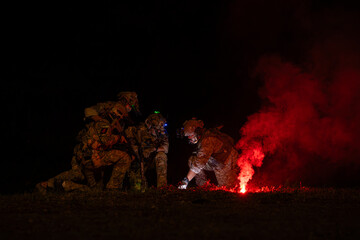 Wall Mural - Group of soldiers in camouflage uniforms hold weapons with patrol missions at night