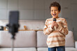 © Prostock-studio - Little Vlogger. Cheerful Black Preteen Boy Singing And Recording Video At Home