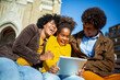 © Mediteraneo - Family sitting on bench, relaxing using digital tablet, shopping online.