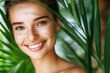 Young beautiful woman with healthy skin with palm leaves on background