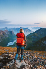 Wall Mural - traveler woman hiking in norway solo in mountains of lofoten islands girl tourist with red backpack 