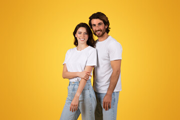 Wall Mural - A happy young couple in casual white t-shirts and blue jeans posing