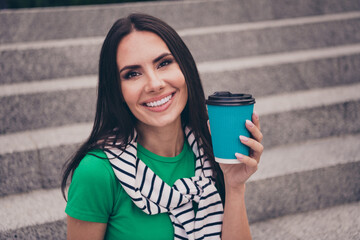 Sticker - Photo of cheerful lovely woman dressed stylish clothes jumper on shoulders holding plastic cup drink outdoors in the city