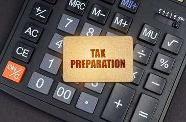 Wall Mural - There is a sign on the calculator that says - Tax preparation