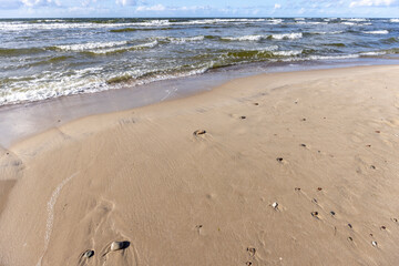 Wall Mural - Picturesque view of the sandy beach of the Baltic Sea, foamy water flowing into the sand, Wolin Island, Miedzyzdroje, Poland