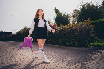 Wall Mural - Photo of attractive excited girl dressed bomber short skirt backpack enjoying travelling new places outdoors urban city park