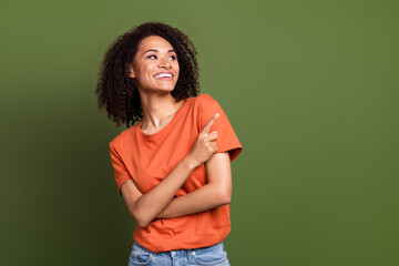 Poster - Photo of thoughtful dreamy lady dressed orange t-shirt looking showing finger empty space isolated khaki color background