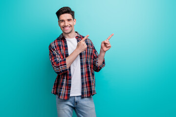 Wall Mural - Photo of sweet charming guy wear checkered shirt showing two fingers empty space isolated blue teal color background